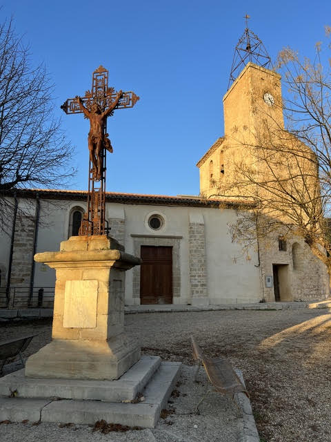 L'église du Barry et sa croix en fer forgé sous la lumière du soir